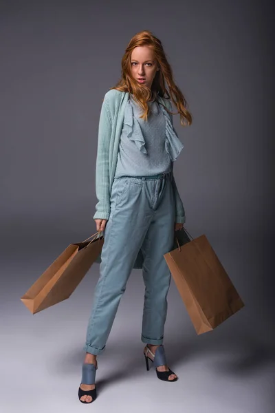 Chica en azul con bolsas de compras - foto de stock