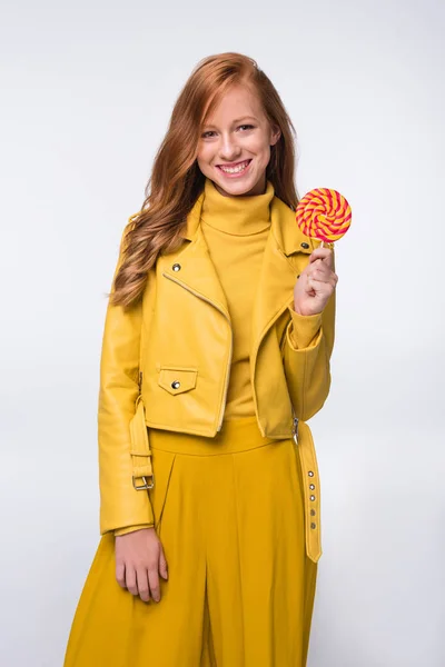 Chica en chaqueta de cuero amarillo con piruleta - foto de stock