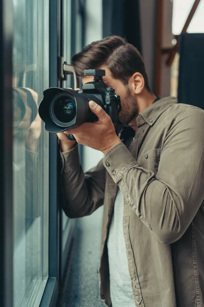 Photographe avec appareil photo à la fenêtre — Photo de stock