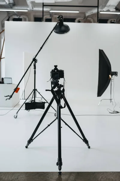 Camera in photo studio with lighting equipment — Stock Photo
