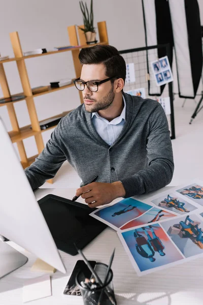 Photographer with graphics tablet and photos — Stock Photo