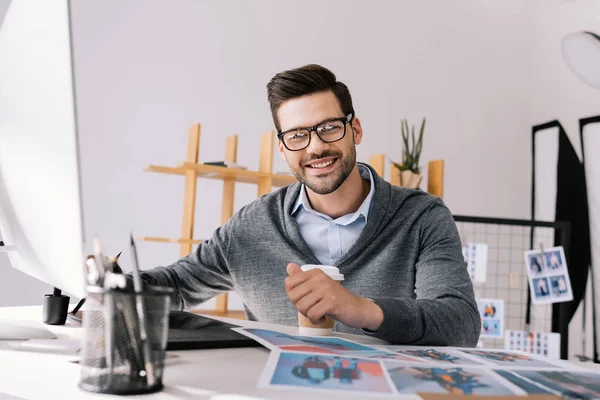 Photographer with graphics tablet and photos — Stock Photo