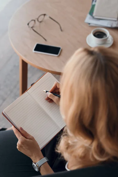 Donna che scrive nel taccuino — Foto stock