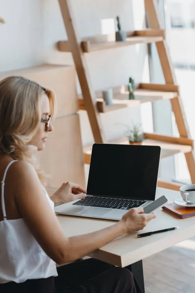 Femme d'affaires avec ordinateur portable et smartphone — Photo de stock