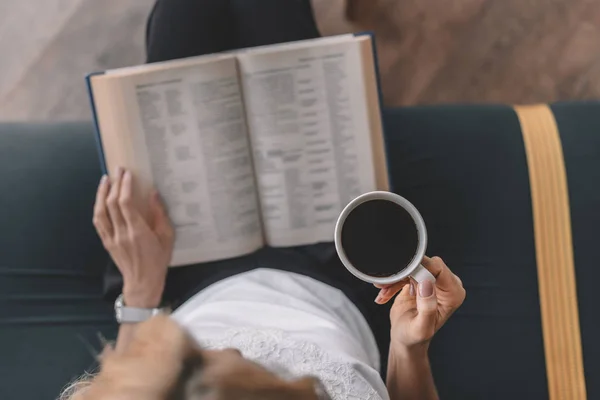 Mujer leyendo libro y bebiendo café - foto de stock