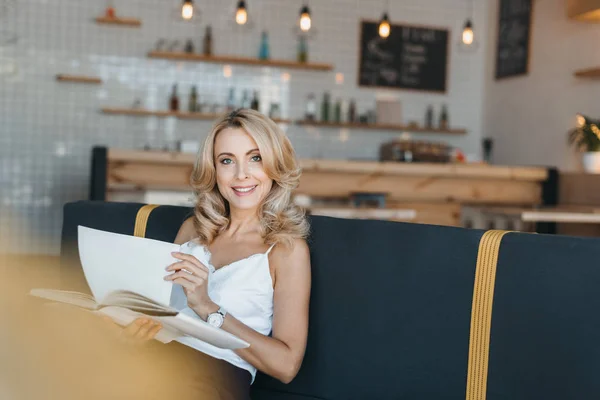Mujer leyendo libro en la cafetería - foto de stock