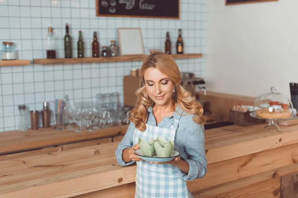 Waitress holding plate with dessert — Stock Photo