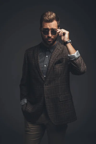 Uomo in giacca e cravatta guardando sopra occhiali da sole — Foto stock