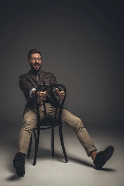 Man in suit sitting on chair backwards — Stock Photo