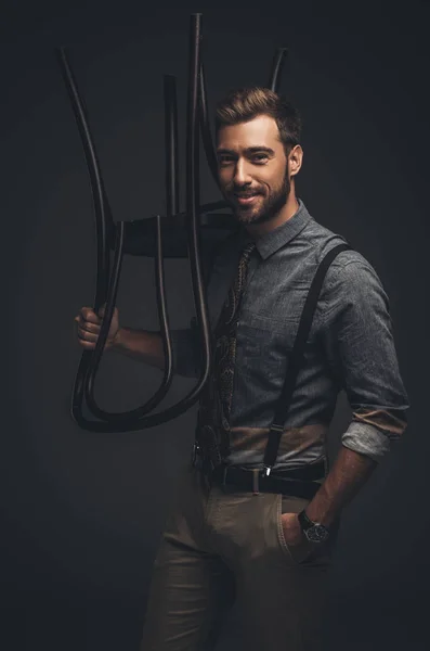 Homem posando com cadeira de madeira — Fotografia de Stock