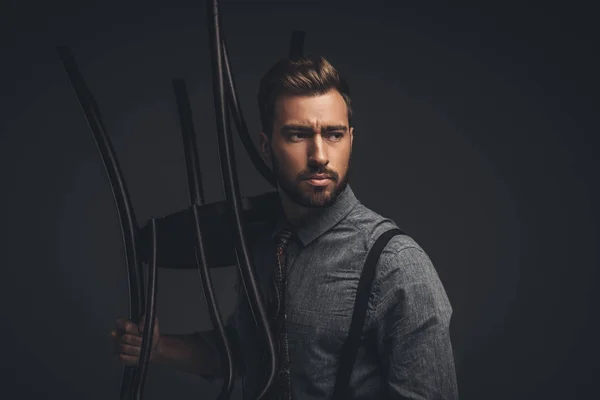 Homem posando com cadeira de madeira — Fotografia de Stock