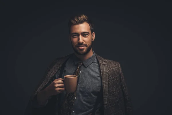 Hombre sonriente sosteniendo una taza de café - foto de stock