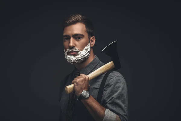 Hombre en crema de afeitar con hacha — Stock Photo