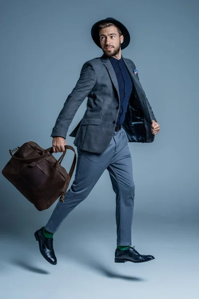Homme en costume marchant avec sac en cuir — Photo de stock