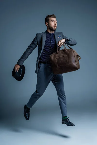 Worried man walking with leather bag — Stock Photo