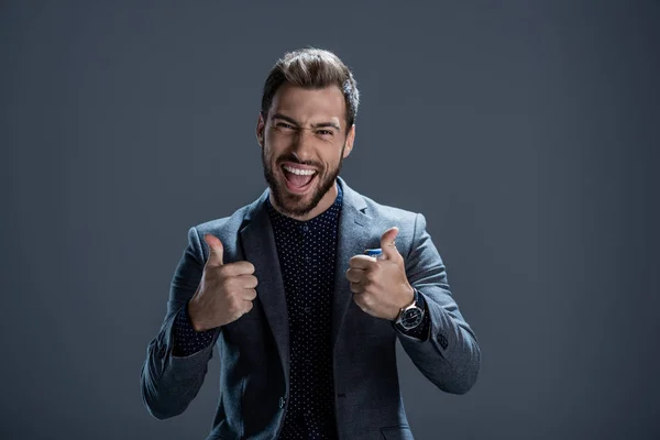 Hombre de traje mostrando pulgares hacia arriba - foto de stock