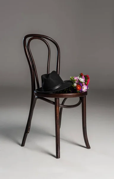 Cadeira de madeira com chapéu e flores — Fotografia de Stock