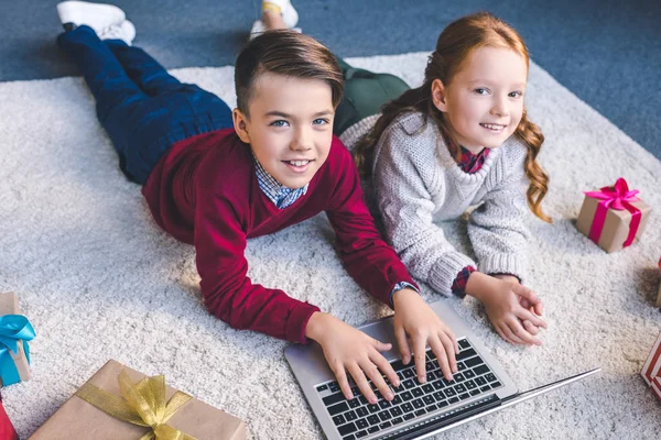 Hermano y hermana usando el portátil juntos - foto de stock