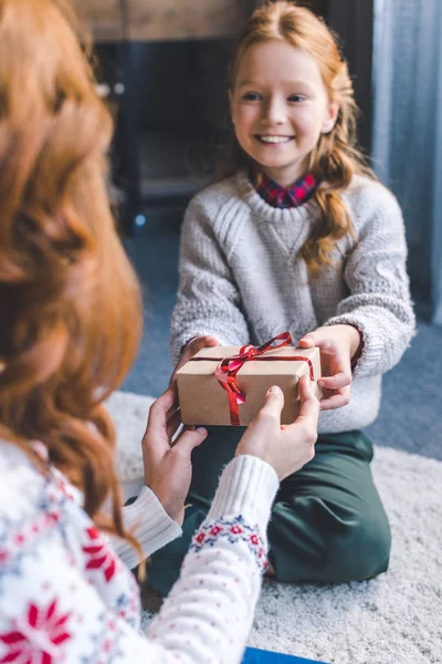 Chica presentando regalo a la madre - foto de stock