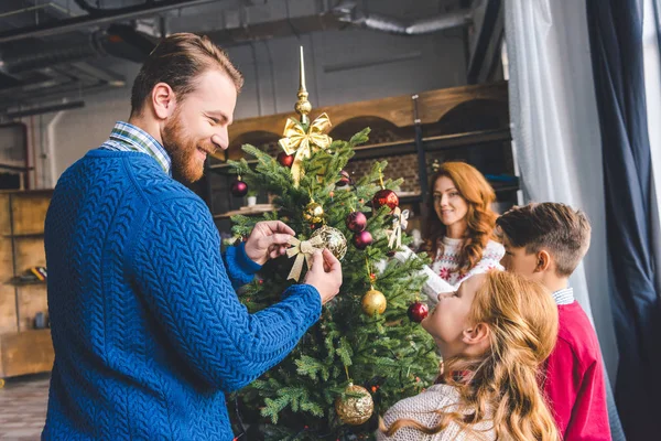 Family decorating christmas tree — Stock Photo