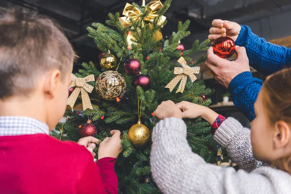 Family decorating christmas tree — Stock Photo