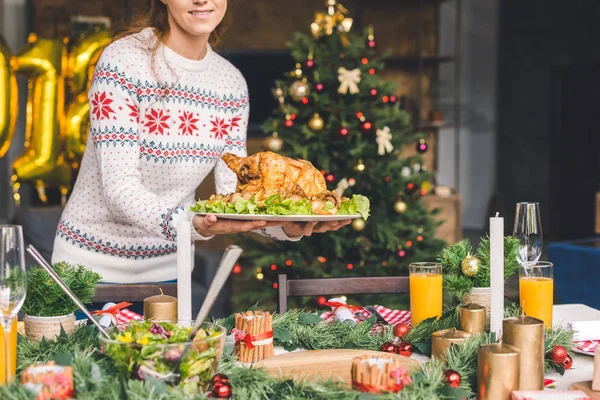 Mujer sirviendo mesa de Navidad con pollo - foto de stock