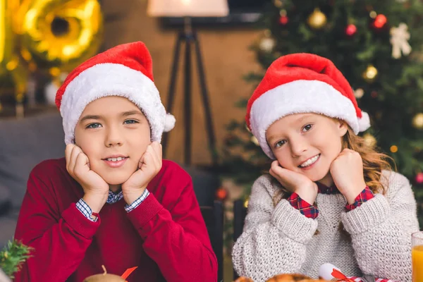 Bruder und Schwester in Weihnachtsmützen — Stockfoto