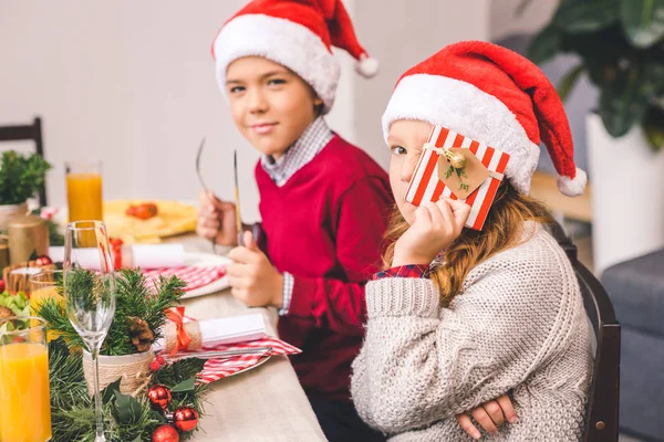 Brother and sister sitting at christmas table — Stock Photo