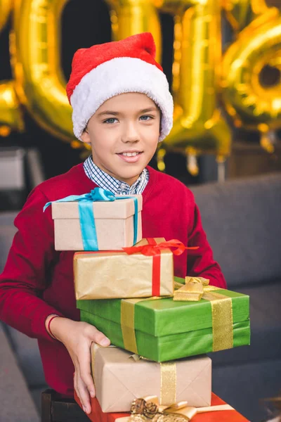 Garçon tenant cadeaux de Noël — Photo de stock