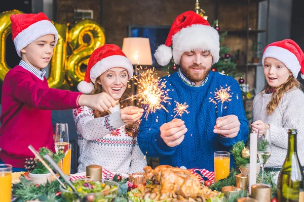 Family with sparkle lights on new year — Stock Photo