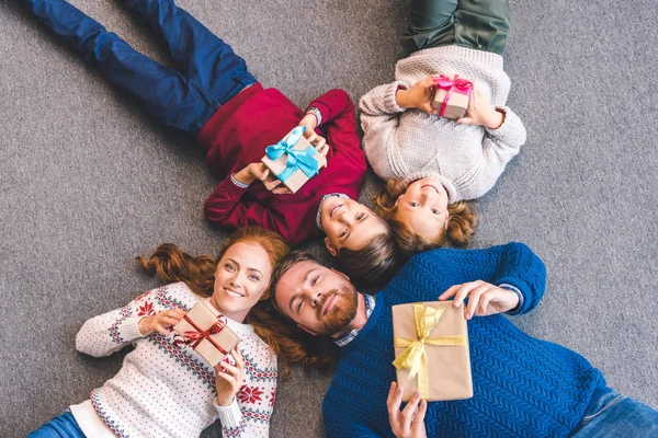 Familie legt sich mit Geschenken auf den Boden — Stockfoto