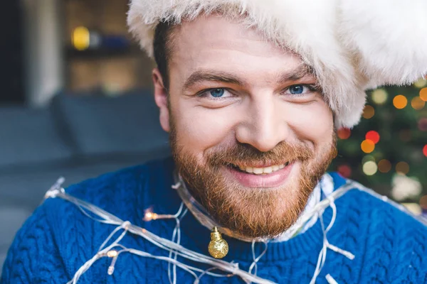 Hombre atado con guirnalda de Navidad - foto de stock