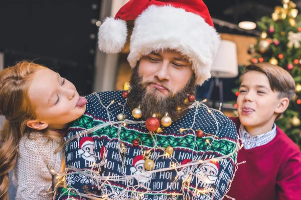 Kids and father tied up with garland — Stock Photo