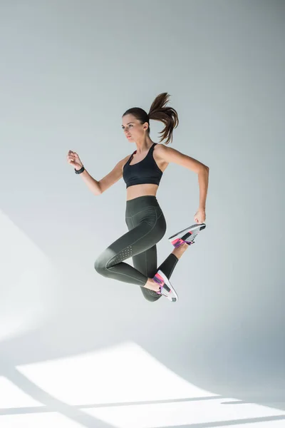 Прыгающая девушка в спортивной одежде — стоковое фото