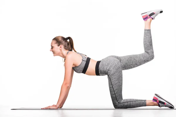 Deportista ejercitándose sobre esterilla de yoga - foto de stock