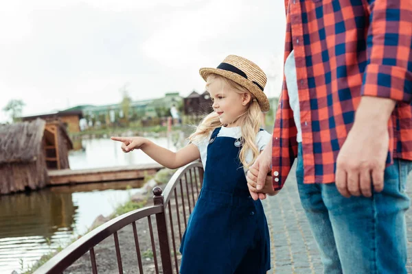 Kind zeigt auf Teich — Stockfoto