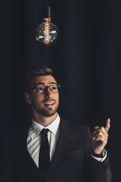 Handsome businessman with lightbulb — Stock Photo