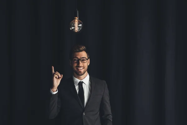 Handsome businessman with lightbulb — Stock Photo