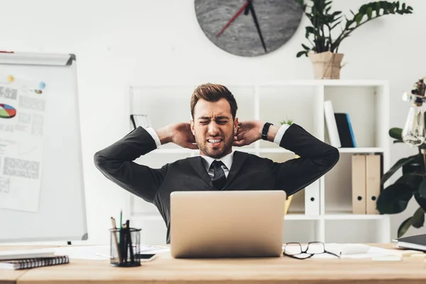 Homem de negócios cansado alongamento no local de trabalho — Fotografia de Stock