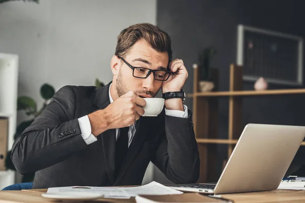 Overworked businessman drinking coffee — Stock Photo