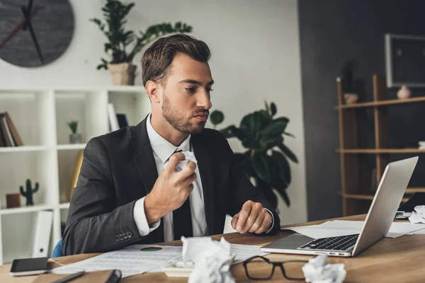 Businessman with crumpled papers — Stock Photo