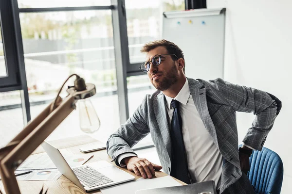 Hombre de negocios con dolor de espalda - foto de stock