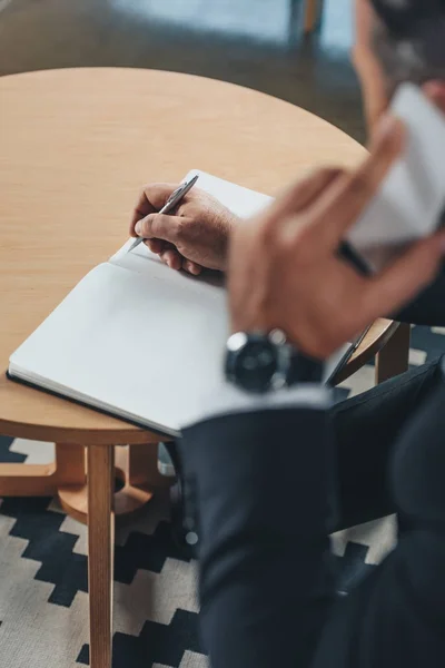 Businessman writing in notebook — Stock Photo