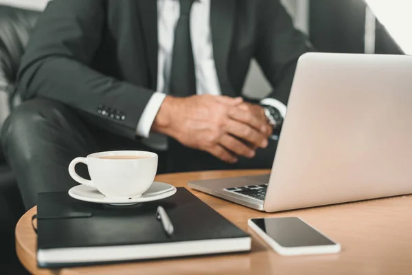 Uomo d'affari con computer portatile e caffè sul tavolo — Foto stock