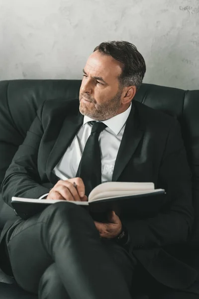 Pensativo hombre de negocios con cuaderno - foto de stock