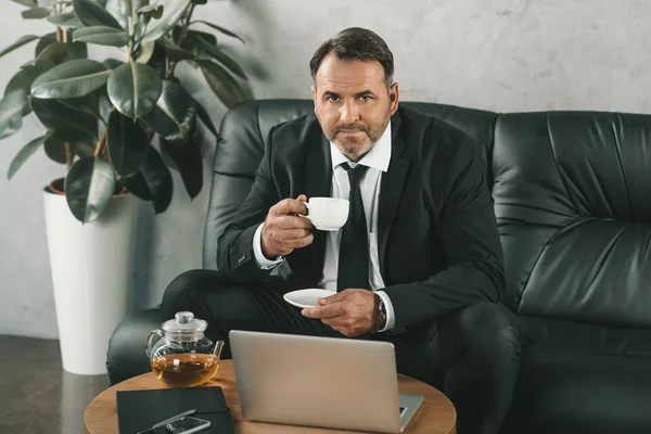 Businessman drinking tea — Stock Photo