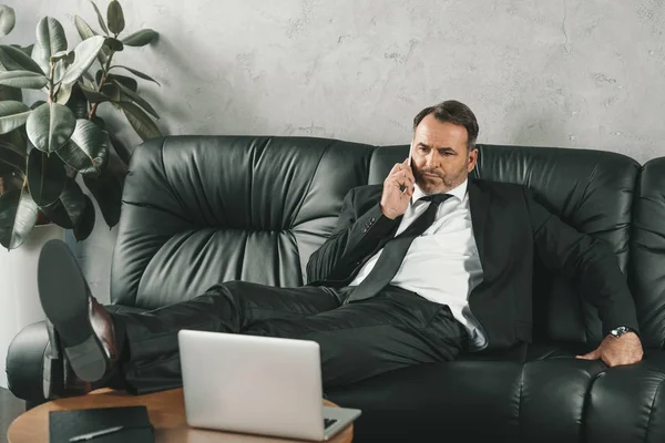 Homme d'affaires parlant par téléphone sur le canapé — Photo de stock