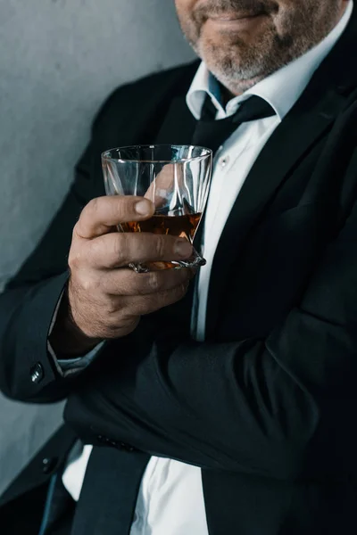 Hombre de negocios con vaso de whisky - foto de stock