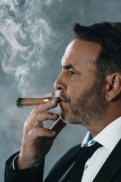 Businessman smoking cigar — Stock Photo