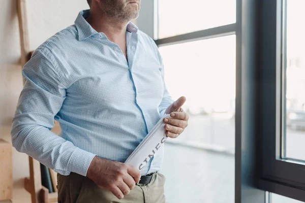 Empresario con periódico enrollado en las manos - foto de stock